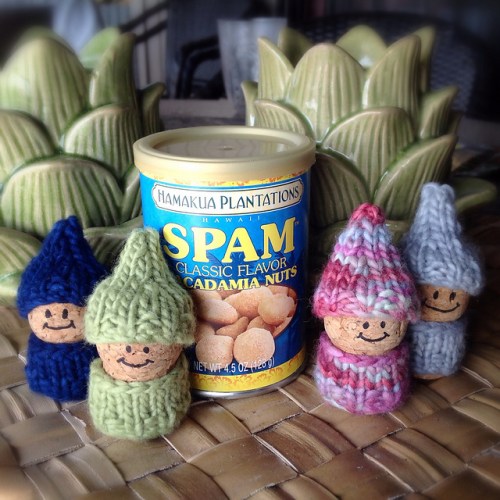 4 korknisse with sweaters and hats knit with malabrigo worsted, and a can of spam macadamia nuts
