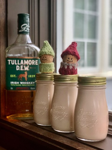 bottles of Irish Cream made with Tullamore DEW whiskey, and two korknisse with knit sweaters and hats