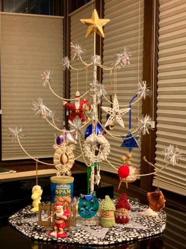 wire christmas tree on top of the piano with assorted ornaments