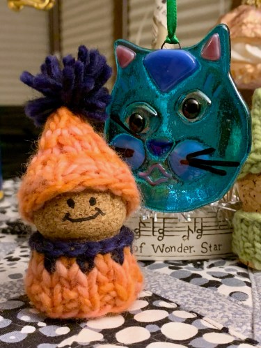 small cork korknisse wearing an orange and navy blue sweater and hat knit with malabrigo worsted