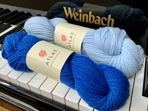  two skeins of Modern Daily Knitting’s Atlas yarn in shades of blue