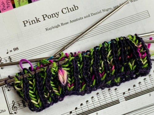 brioche knit swatch in dark purple and vivid green, with assigned pooling in pink and yellow