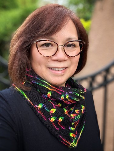 woman wearing a handknit cowl featuring assigned pooling motifs