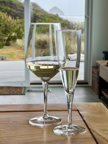 two glasses of wine, another Haystack Rock in the background