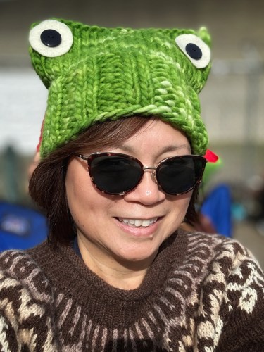 Woman wearing a bright green frog hat