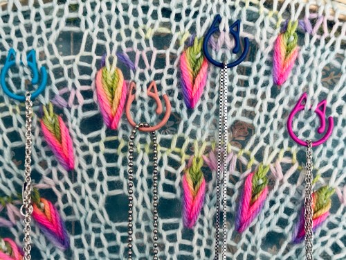 cat clip stitch markers on assigned pooling knit fabric