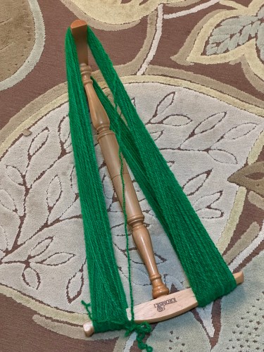 green yarn on a niddy noddy