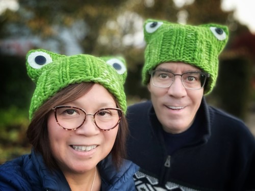 two people wearing green knit hats