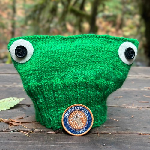 Green knit hat and Feminist Knit Club patch