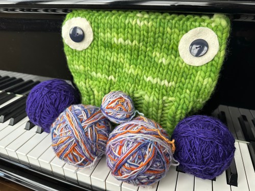 Balls of yarn and a green Portland Frog Hat