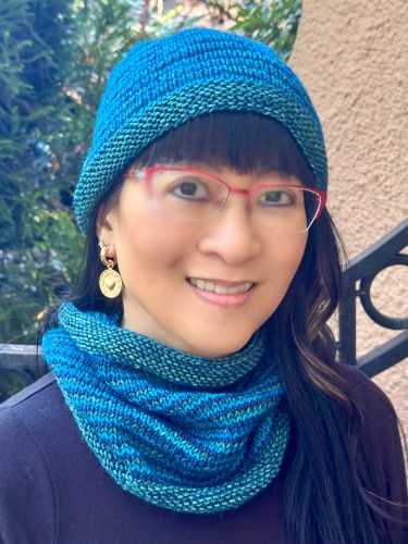 woman wearing hand knit striped hat and cowl